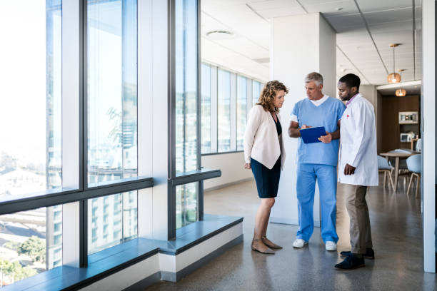 doctores discutiendo sobre portapapeles en hospital - full length clipboard african ethnicity black fotografías e imágenes de stock