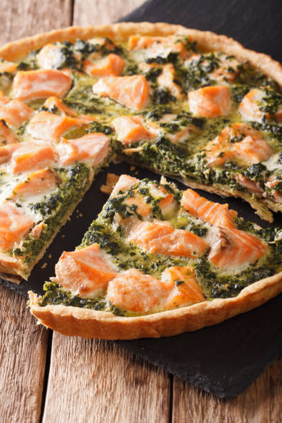 istock Delicious sliced tart with salmon and spinach, close-up. vertical 966275568
