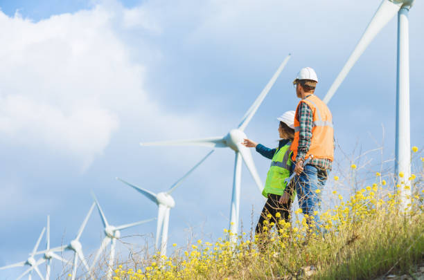 istock Young engineers looking and checking wind turbines at field 966285118
