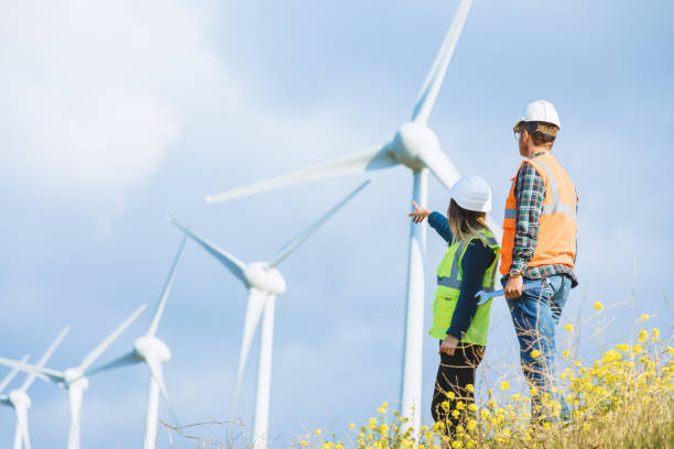 istock Young engineers looking and checking wind turbines at field 966285484