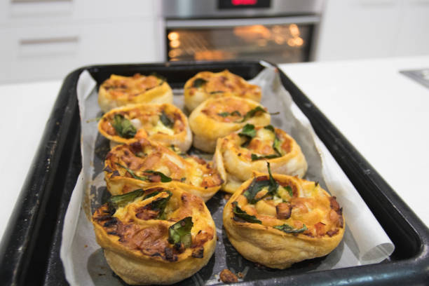 Home cooking vegetable scrolls with yummy golden puff pastry on a baking tray fresh out of an oven