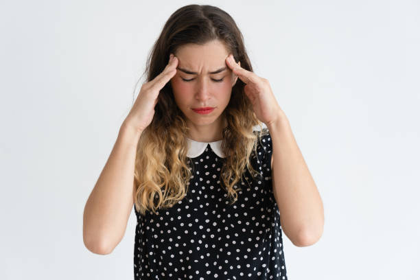 istock Tensed pretty young woman touching temples and thinking hard 966290486