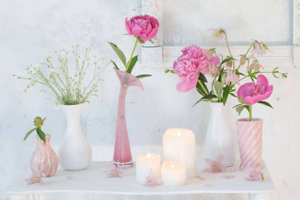 istock flowers in vases and candles on white background 966294798