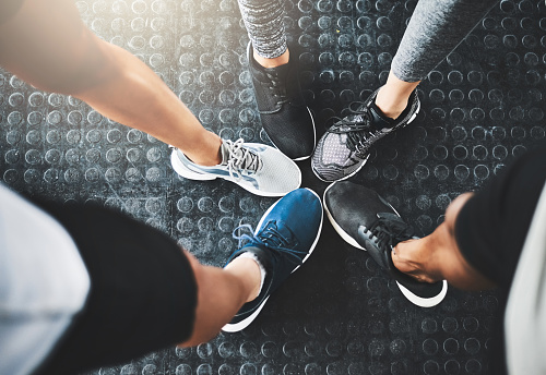 Cropped shot of a group of people standing together in a circle at the gym