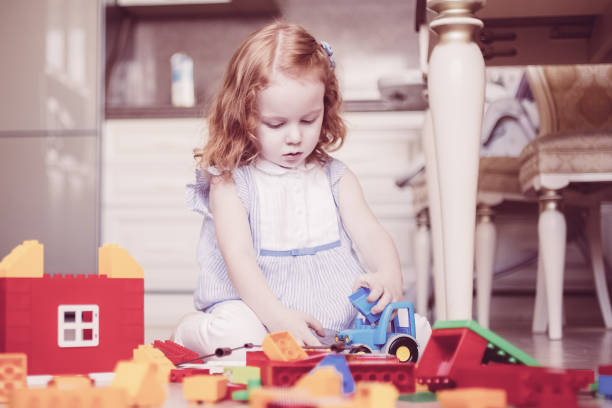 istock Serious little girl playing with erector set 966306216