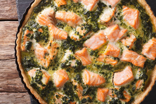 istock tart with red fish, spinach and herbs in baking dish close up on a table. Horizontal top view 966310452
