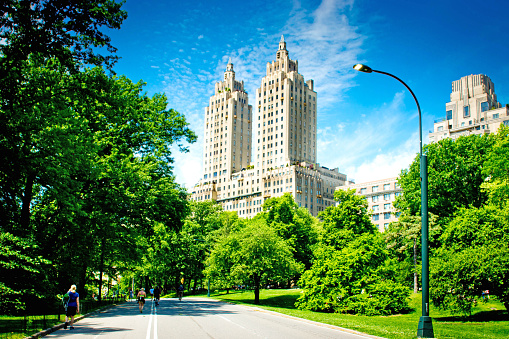 The Eldorado at 300 Central Park West, on the Upper West Side of Manhattan, with tourists walking towards it on the cycle paths that criss cross the Park.