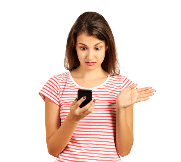 istock surprised student girl dressed in a striped top, embarrassed puzzled look in holding a smartphone in her hands, bewildered. emotional girl isolated on white background 966330218