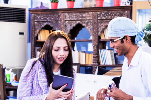 istock Female restaurant visitor ordering meal using a digital tablet to a waiter 966336112