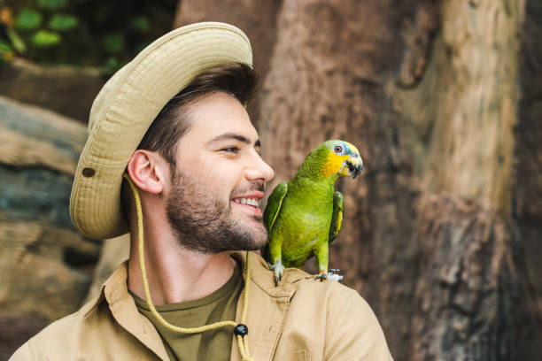 istock handsome young man with parrot on shoulder in jungle 966346134