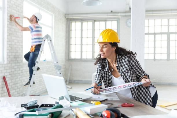 Woman and manual worker making home renovation Couple making home renovation, painting, using laptop. Property Services. New Home. design color swatch painting plan stock pictures, royalty-free photos & images