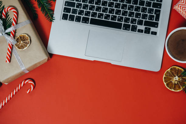 istock Christmas work space with laptop, hot chocolate, candies on red background. Top view, space for text 966356018