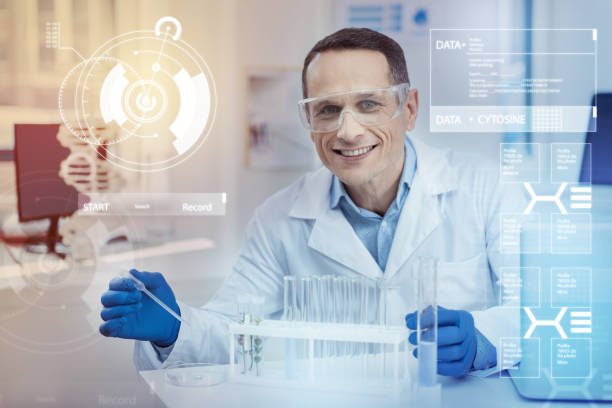 istock Cheerful scientist holding a pipette while conducting experiments with liquids 966356398