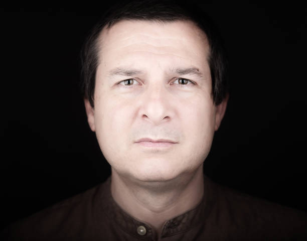 Close up of confused adult man's face on gray background