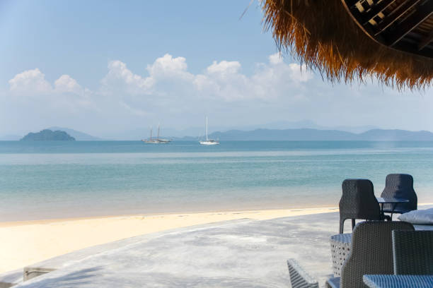 istock A chaise longue under on the sandy beach by the sea and sky with copy space 966365976