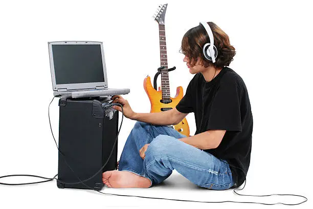 Photo of Boy Teenager With Electric Guitar Amp And Laptop