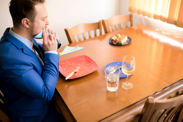 Businessman in a blue suit finishing his main course stock photo