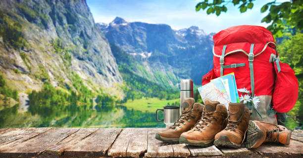 lake landscape with big backpack and trekking boots lake landscape with big backpack and trekking boots in mountains camping stock pictures, royalty-free photos & images