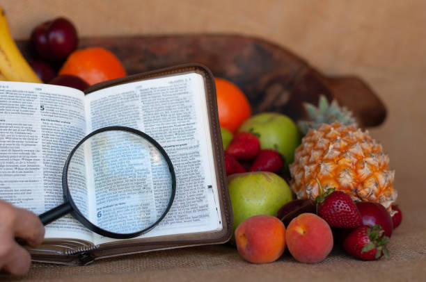 фруктовая чаша с библией и увеличительным стеклом - magnification bible magnifying glass book стоковые фото и изображения