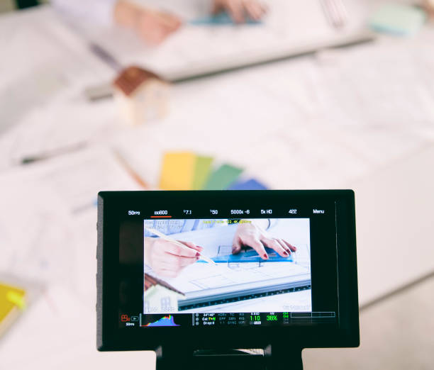 istock Filming video of architect working in office with professional video camera 966385330