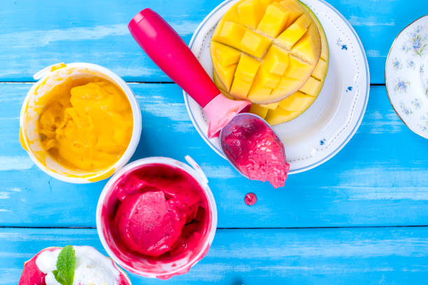 istock Fruit ice cream in buckets, on a blue wooden background and mango. Flut lay 966399054