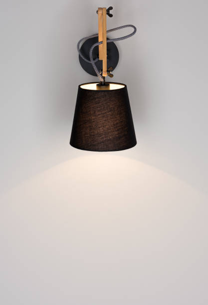 istock Black modern wall light shines on a gray wall. Free space 966400284