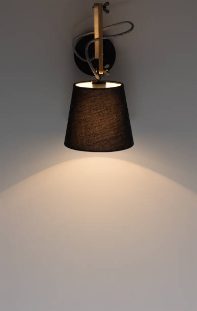 istock Black modern wall light shines on a dark gray wall. Free space 966400322