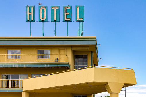 Dirty old hotel sign on the top of a highway motel in an American city