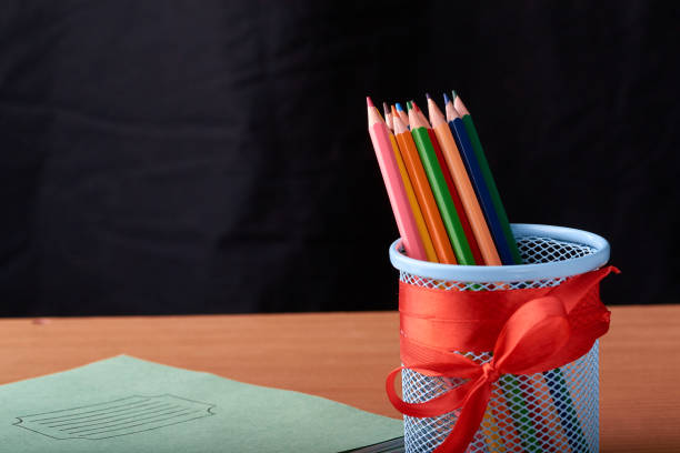 istock School and office supplies on classroom table in front of blackboard. View with copy space 966407836