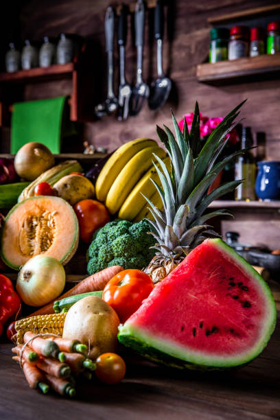 istock Assorted organic tropical fruits and vegetables in a rustic kitchen background. Natural lighting 966412298