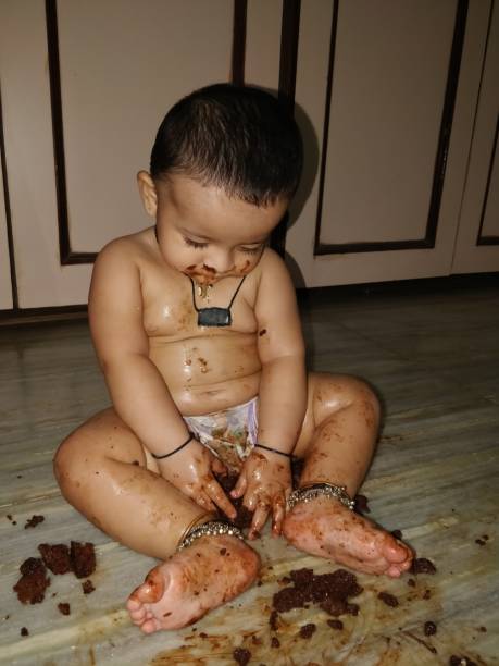 istock Adorable baby girl making mess while feeding herself 966412638