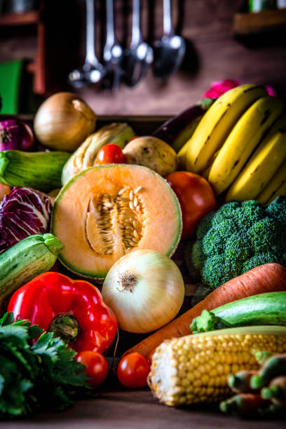 istock Assorted organic tropical fruits and vegetables in a rustic kitchen background. Natural lighting 966415066