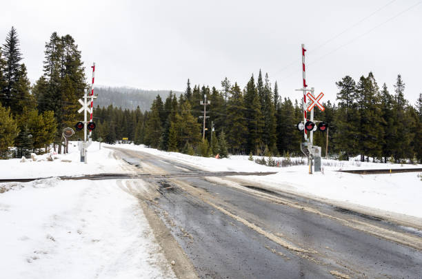 Railroad Crossing along a Mountain Road on a Snowy Day
