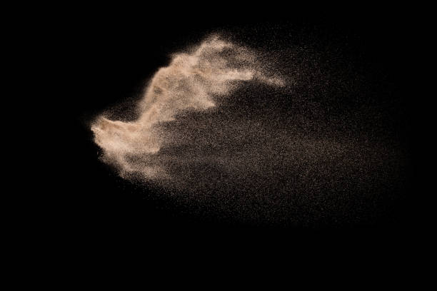 istock Abstract sand cloud. Golden colored sand splash agianst dark background. Yellow sand fly wave in the air. Sand explode on black background ,throwing freeze stop motion. 966419568