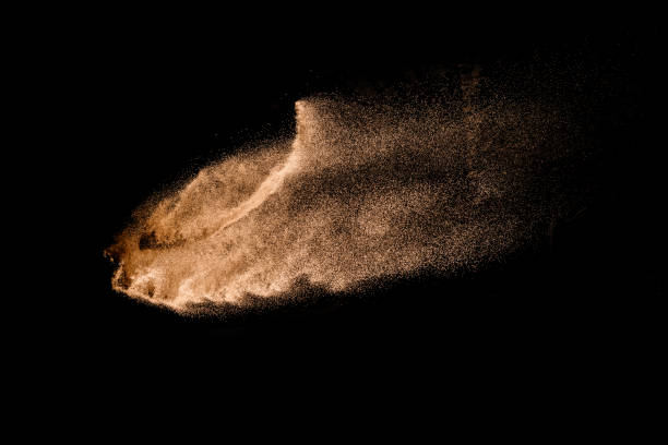 istock Abstract sand cloud. Golden colored sand splash agianst dark background. Yellow sand fly wave in the air. Sand explode on black background ,throwing freeze stop motion. 966419614