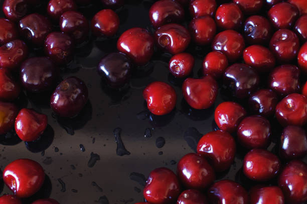 Close-up of a sweet cherry on a black wet background
