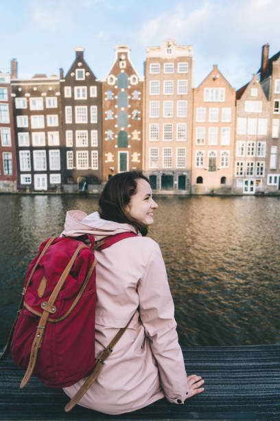 istock Woman walking near canal in Amsterdam at sunset 966425708