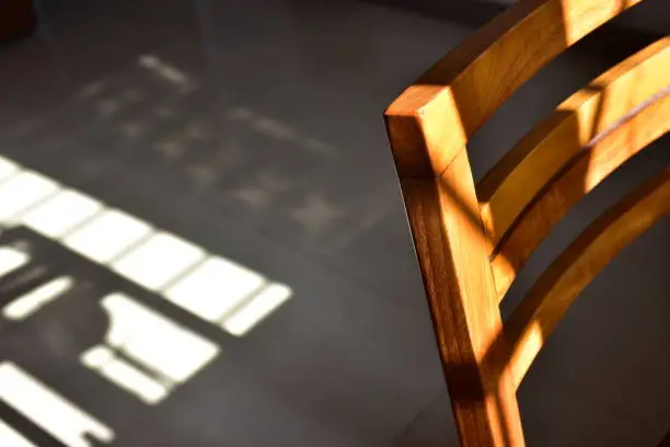 Close up of a wooden chair under sunlight.