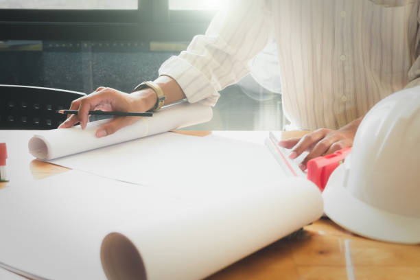 istock Architect or engineer working in office with blueprints,engineer inspection in workplace for architectural plan,sketching a construction project ,selective focus,Business construction concept. 966426668
