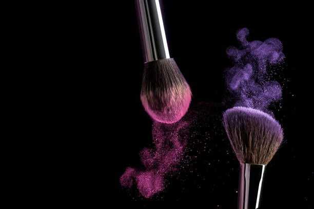 istock Make-up brush concept with ultraviolet and pink powder explosion isolated on black background. 966438314