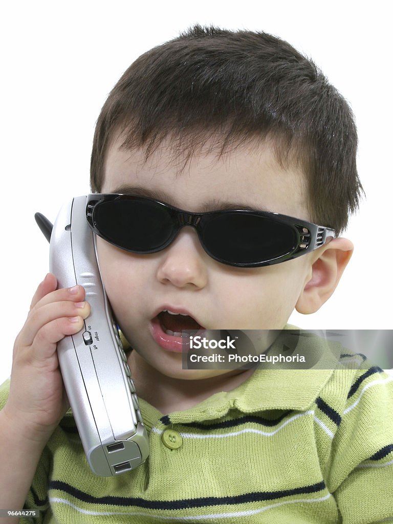 Garçon à lunettes de soleil parler sur le téléphone sur blanc - Photo de Choc libre de droits
