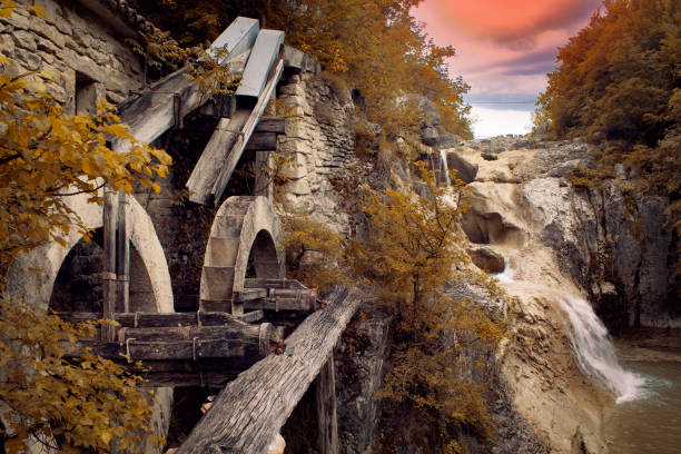 Took a shot of an old water mill, behind him the are smo water falls with the orange sun