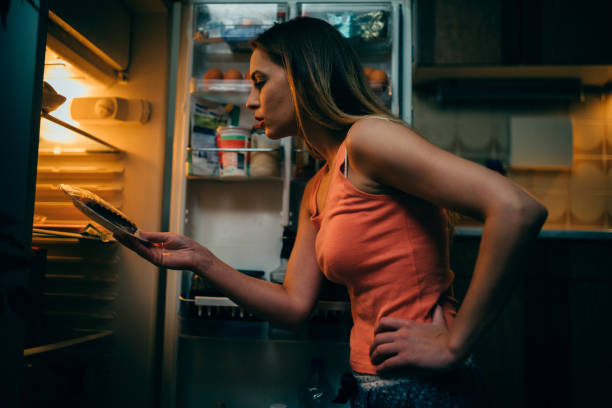 istock Young woman having a late night snack in the kitchen 966452756