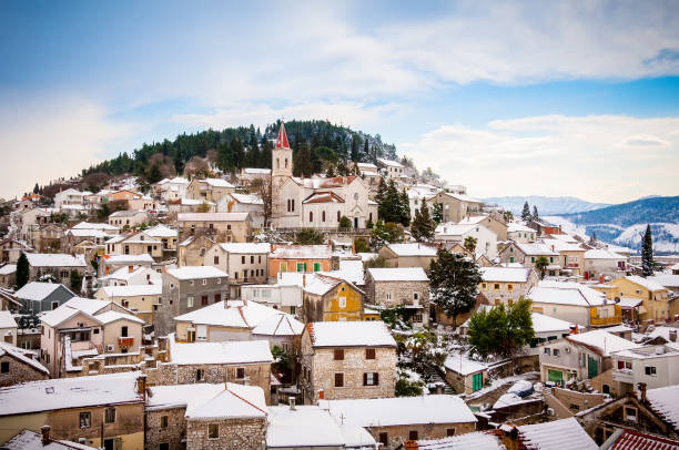 雪に覆われた上に、教会と丘の斜面に小さな地中海の町 - town village hill panoramic ストックフォトと画像