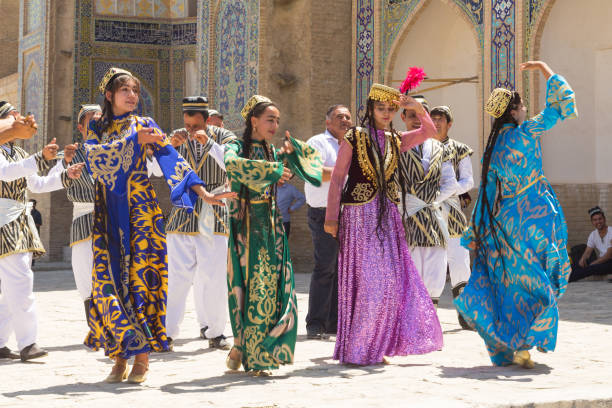 Bukharian musicians in local dress dance, in Bukhara, Uzbekistan. stock photo