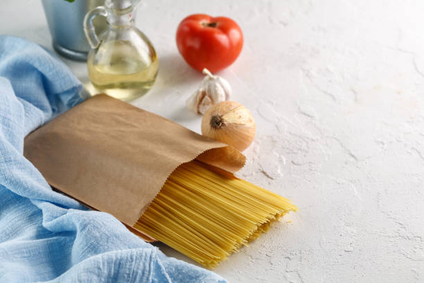 istock raw italian pasta spaghetti with vegetables on white background 966474634
