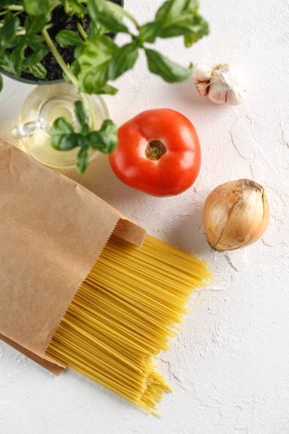 istock raw italian pasta spaghetti with vegetables on white background 966474714