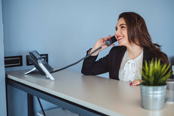 Receptionist girl talking on the phone and smiling stock photo