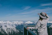 Stylish girl posing against clear sky and snowy mountain peaks