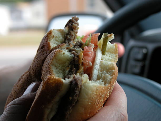 istock A hand holding a burger in a car 96648214